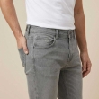 Close-up view of grey regular jeans fabric and pocket design