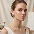 Close-up of elegant square stud earrings with sparkling sapphire blue stones